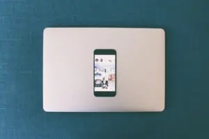 Person browsing social media on a laptop and phone
